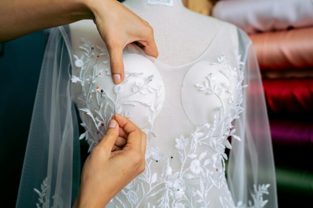 Experienced seamstress sewing a custom white bridal gown in NYC studio